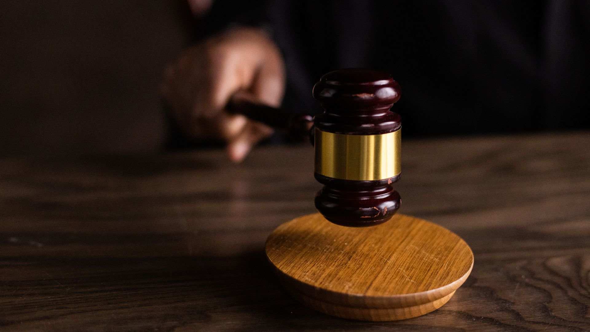 A courtroom desk with a judge’s hand on a gavel, ruling on a case of Texas eviction.